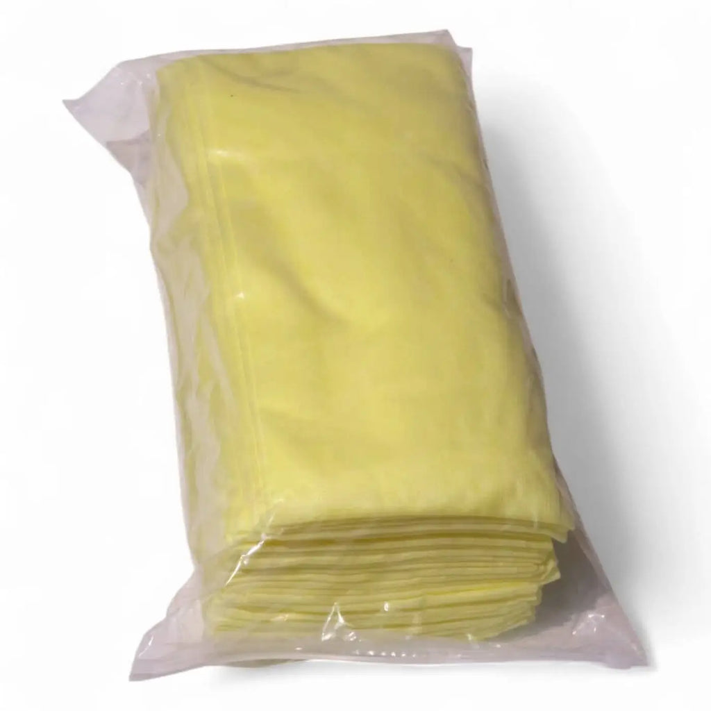 A stack of pale yellow clendo staubbindetuch polypropylene microfiber cleaning cloths in clear plastic packaging