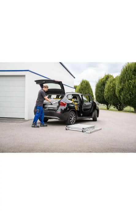 Schwarzer bmw suv mit offenen hinter- und seitentüren sowie aluminiumrädern neben dem munk flexxtower ein-personen-gerüst