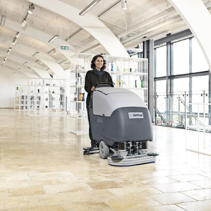 Grau schwarzer Nilfisk Scheuersaugmaschine BA 651 mit modernem Design und Ladegerät für effiziente Bodenreinigung