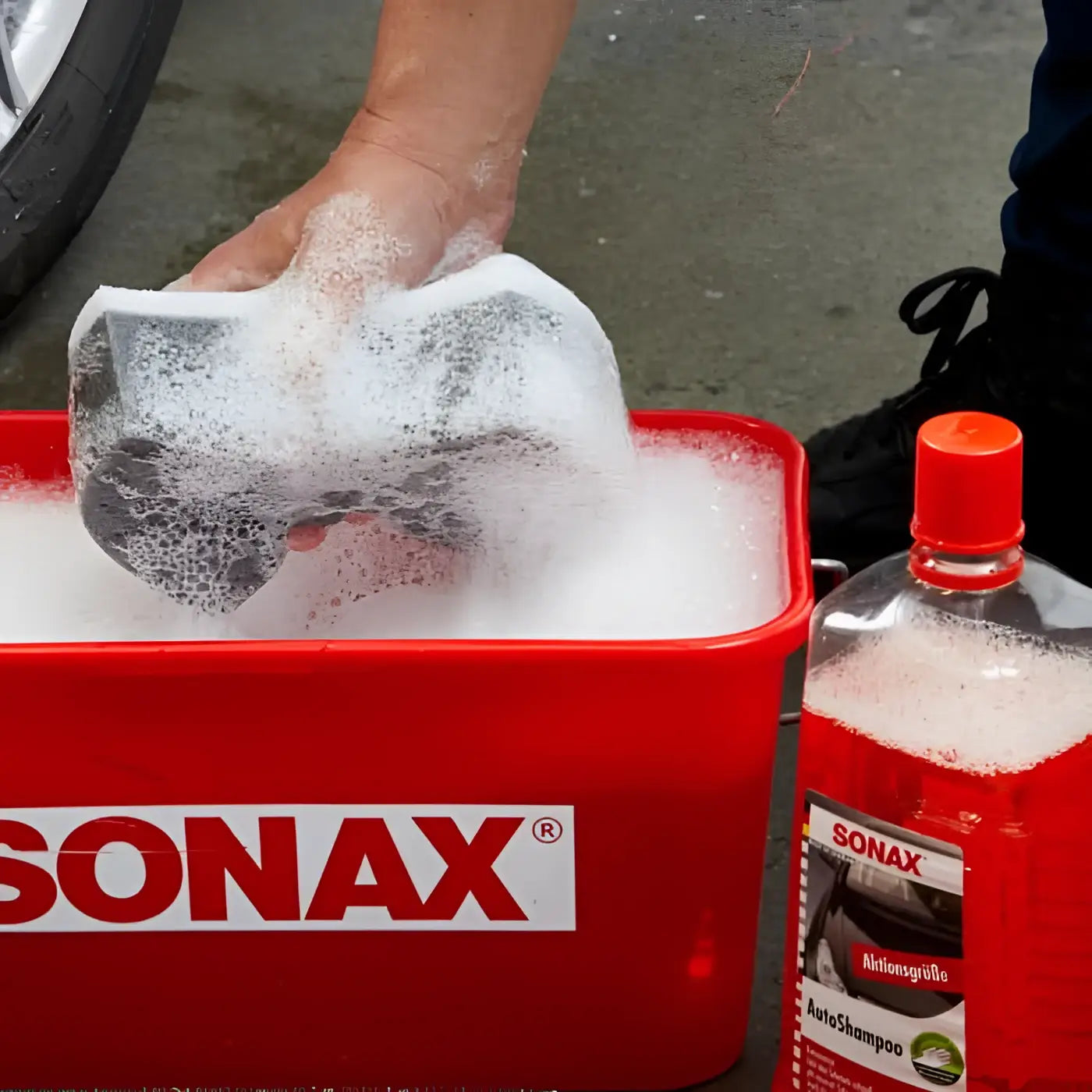 Roter sonax auto shampoo konzentrat 2l eimer mit schaum und hand die schwarzen gummischaumstoff reinigt