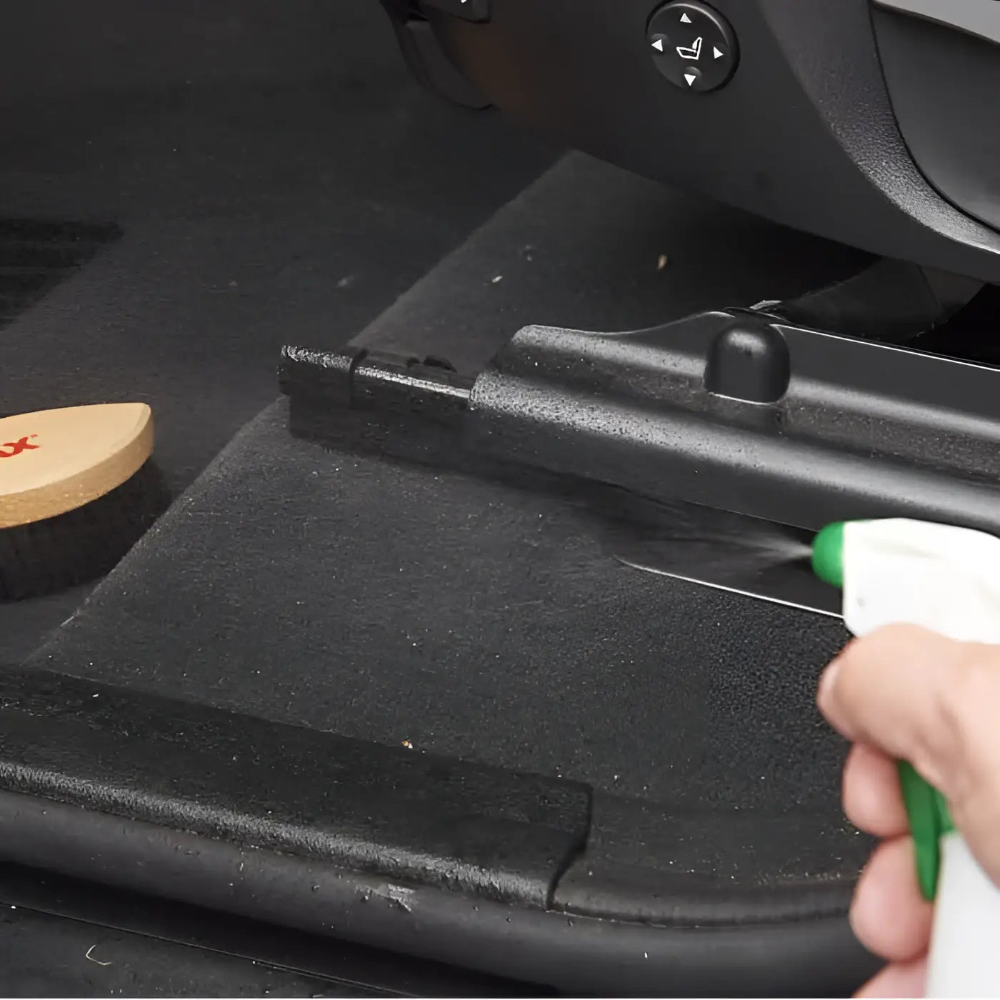 Schwarze kunststoff-autofußmatte mit strukturierter oberfläche und geformten kanten sonax textil lederbürste