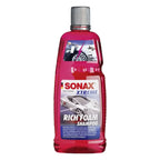 Vibrante rote plastikflasche sonax xtreme rich foam shampoo 1l mit silberner schraubkappe und sportwagenetikett