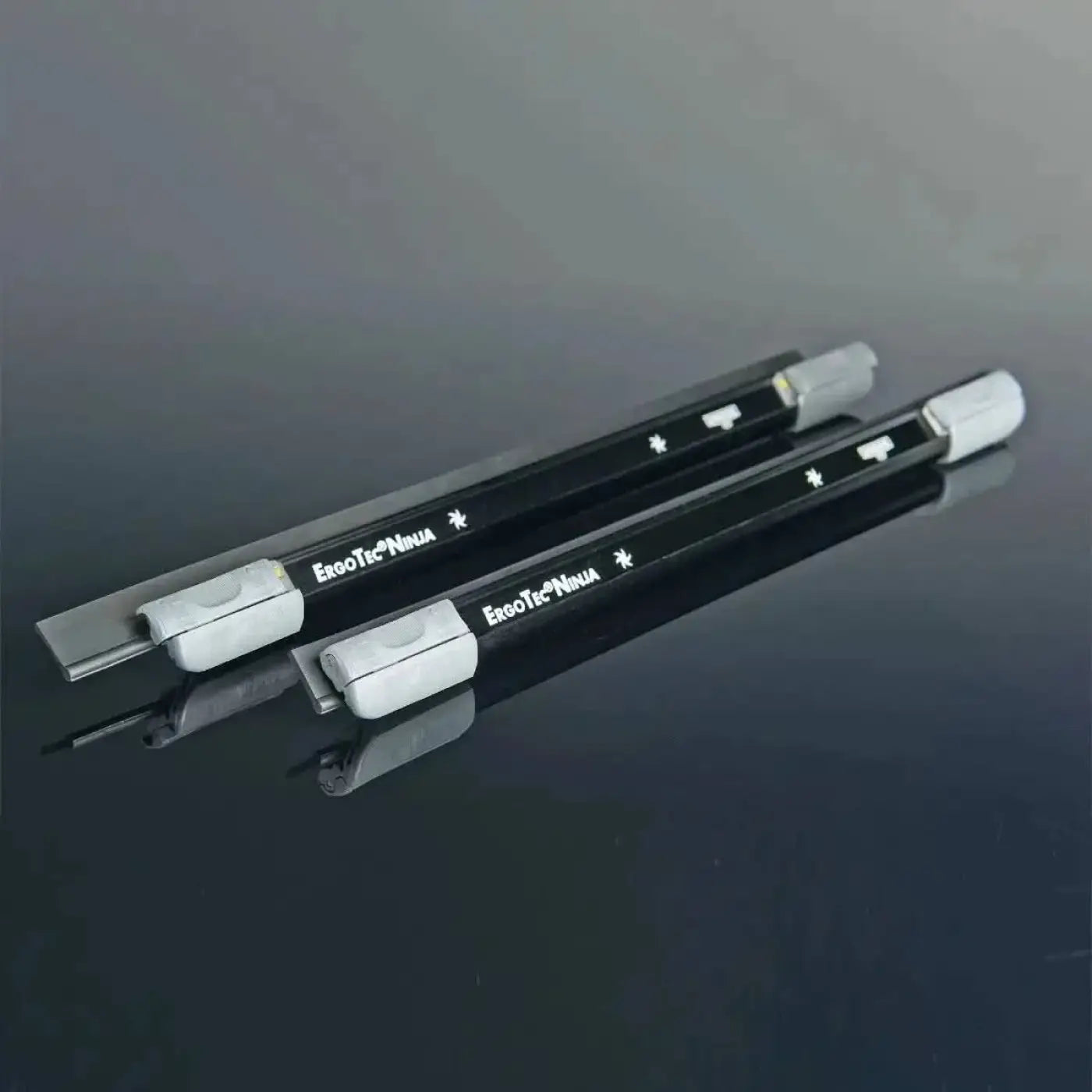 Schwarze ergotec ninja utility knives mit silbernen klingen und weißen kunststoffgriffen im unger ergotec ninja fensterwischer 40° en design