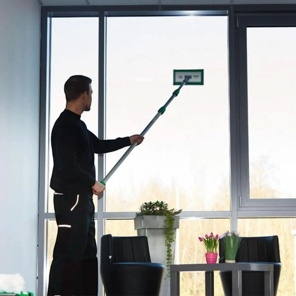 Grüner und silberner teleskop-fensterwischer mit rechteckigem kopf aus dem unger glas-innenreinigung starter set pfk20